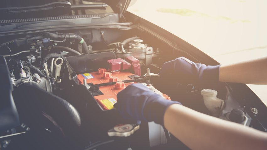 Mecanico arreglando la bateria del auto