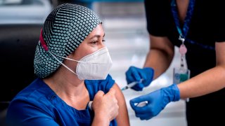 Fotografía cedida por la Presidencia de Chile que muestra a la enfermera Zulema Riquelme mientras recibe la vacuna contra el COVID-19, en el Hospital Metropolitano de Santiago (Chile).