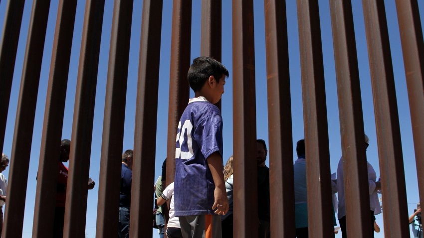 A boy from the Anapra area observes a binational prayer performed by a group of religious presbyters by migrants on the border wall between Ciudad Juarez, Chihuahua state, Mexico and Sunland Park, New Mexico, US, on May 3, 2018. (Photo by Herika Martinez / AFP)        (Photo credit should read HERIKA MARTINEZ/AFP via Getty Images)