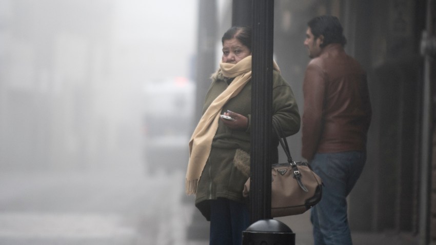 Dos personas en la calle envuelta en bruma por frío