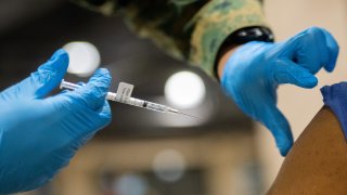 Close up of a needle going into an arm