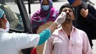 In this March 24, 2021, file photo, a health worker collects a swab sample from a man for the COVID-19 Rapid Antigen Test (RAT) at the Inter-State Bus Terminus (ISBT), in New Delhi.