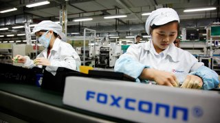 Empleados de Foxconn en la línea de montaje en Longhua, Shenzhen, China.