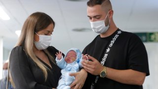Foto de pareja con su bebé que nació tras el primer trasplante de útero en España.