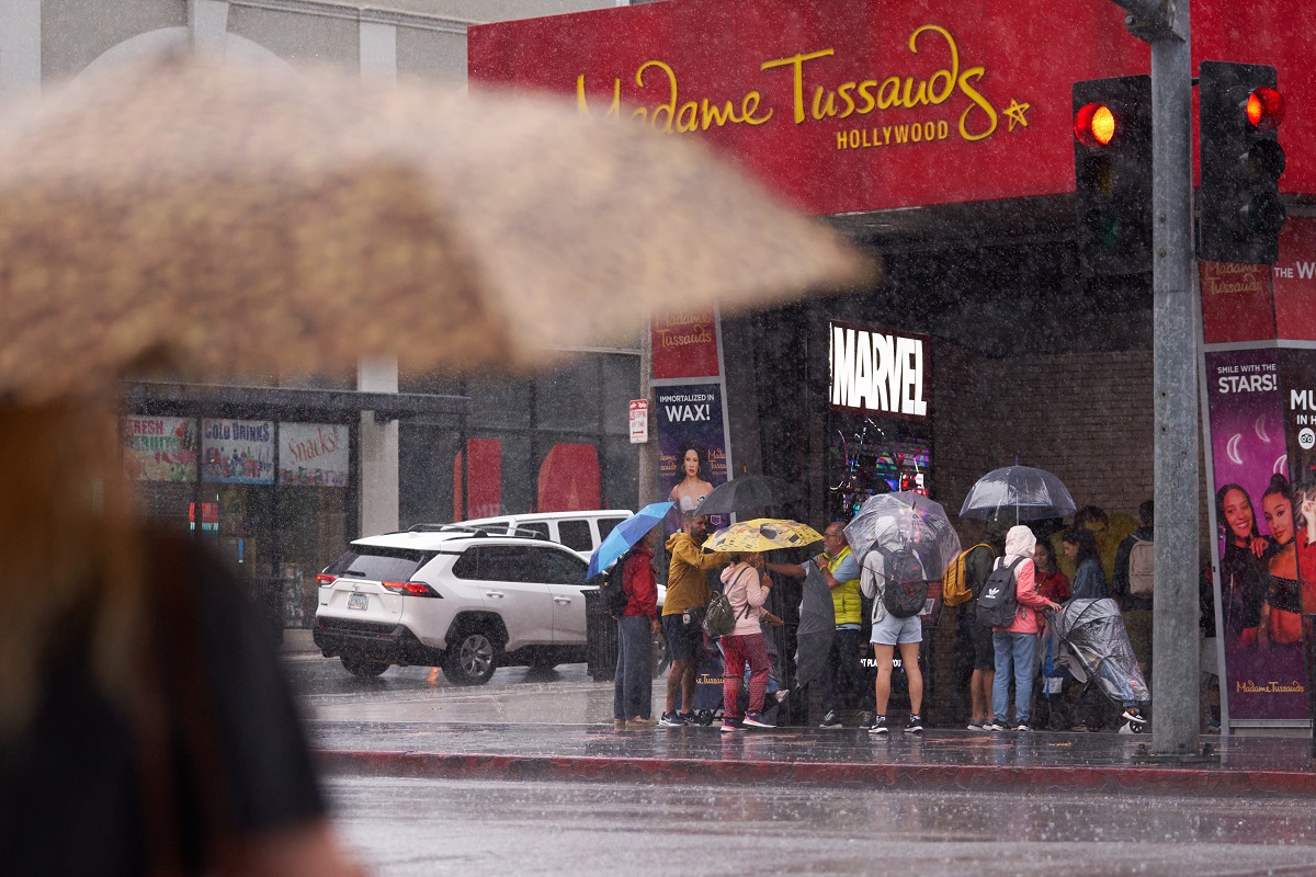 Personas tratan de refugiarse de la lluvia a lo largo de Hollywood Boulevard cuando la tormenta tropical Hilary llega a Los Ángeles, California. EFE/EPA/CENA DE ALLISON