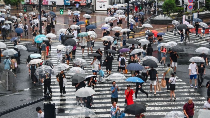 TOPSHOT – Pedestrians use their umbrellas to shelter from the rain while walking across Shibuya Crossing in central Tokyo on August 16, 2024, as Typhoon Ampil approaches the Japanese capital. The “very strong” typhoon buffeted Japan’s Pacific coast with fierce winds and heavy rain on August 16, forcing the cancellation of hundreds of flights and trains in the Tokyo area and leaving over 2,000 homes without power. (Photo by Richard A. Brooks / AFP) (Photo by RICHARD A. BROOKS/AFP via Getty Images)