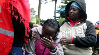 Personal de la Cruz Roja de Kenia y familiares tratan de consolar a una mujer tras un incendio en la residencia de la escuela de primaria Hillside Endarasha, en Nyeri, Kenia, el 6 de septiembre de 2024.