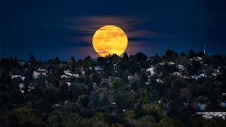 La Superluna, la Luna más grande y brillante del año, se eleva sobre un vecindario, el 17 de octubre de 2024, en Colorado Springs, Colorado.