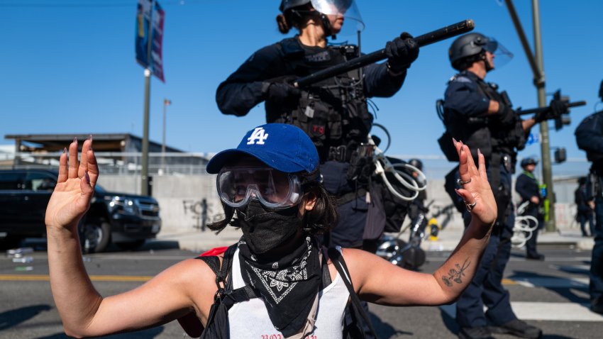 LOS ANGELES, CALIFORNIA – JUNE 08: A protester raises their hands in front of LAPD officers during protests after a series of immigration raids on June 08, 2025 in Los Angeles, California. Tensions in the city remain high after the Trump administration called in the National Guard against the wishes of city leaders. (Photo by Spencer Platt/Getty Images)1