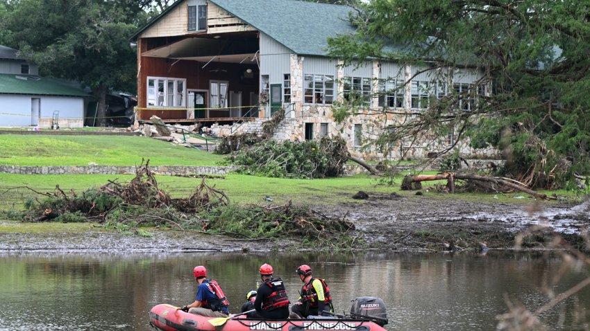 TOPSHOT &#8211; A search and rescue team looks for people along the Guadalupe River near a damaged building at Camp Mystic in Hunt, Texas, on July 7, 2025, following severe flash flooding that occurred during the July 4 holiday weekend. Rescuers in Texas continue to race against time to find dozens of missing people, including children, swept away by flash floods that killed more than 80 people, with forecasters warning of new deluges. In a terrifying display of nature&#8217;s power, the rain-swollen waters of the Guadalupe River reached treetops and the roofs of cabins in Camp Mystic as girls slept overnight on Friday, July 4, washing away some of them and leaving a scene of devastation. (Photo by RONALDO SCHEMIDT / AFP) (Photo by RONALDO SCHEMIDT/AFP via Getty Images)