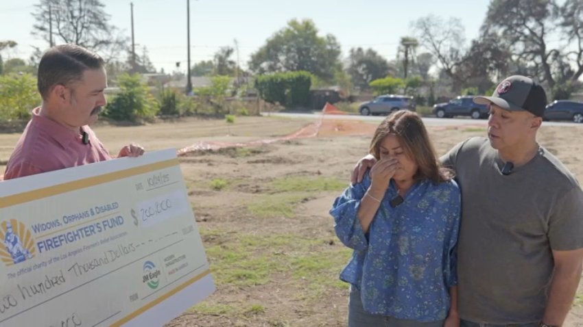Al and Carmen Hugo are presented with a $200,000 check to help them rebuild their home.